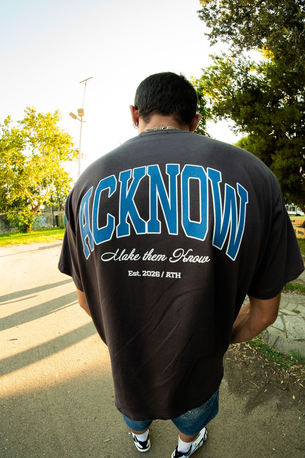 Model wearing the Make Them Know T-shirt, showing the back graphic
