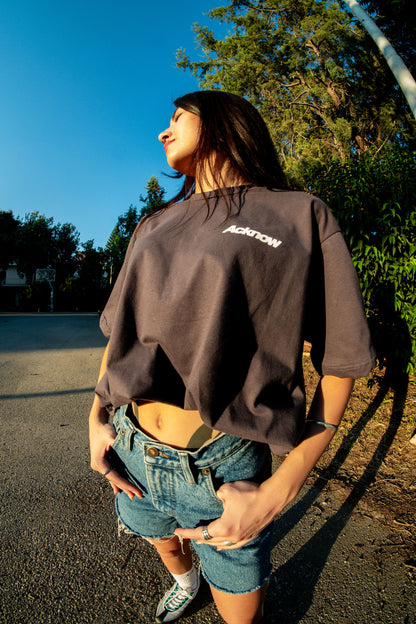 Model wearing the grey Acknow Make Them Know T-shirt outdoors
